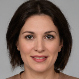 Joyful white adult female with medium  brown hair and brown eyes