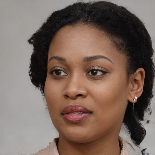 Joyful black young-adult female with medium  black hair and brown eyes