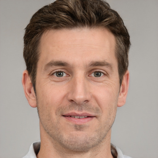 Joyful white adult male with short  brown hair and grey eyes