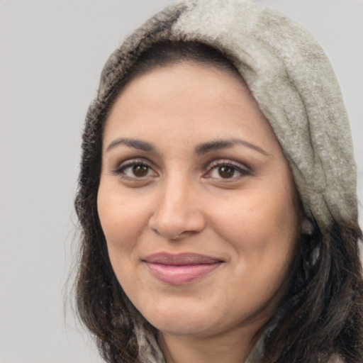 Joyful latino adult female with long  brown hair and brown eyes