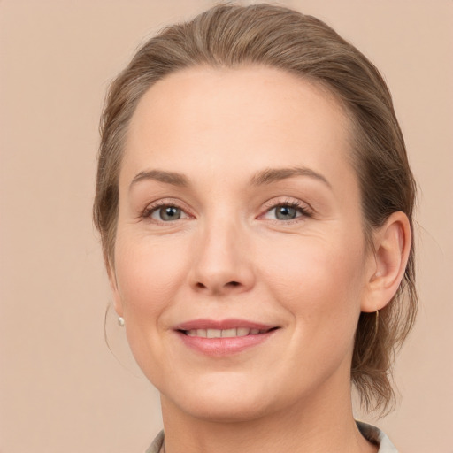 Joyful white young-adult female with medium  brown hair and grey eyes