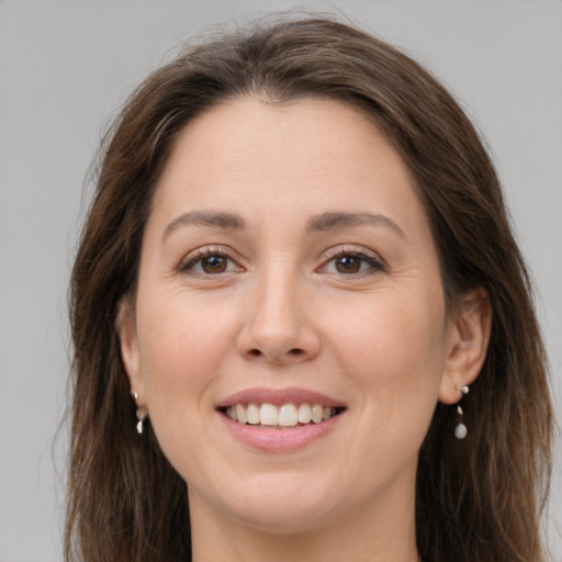 Joyful white young-adult female with long  brown hair and brown eyes