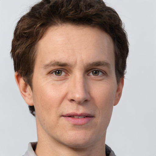 Joyful white adult male with short  brown hair and grey eyes