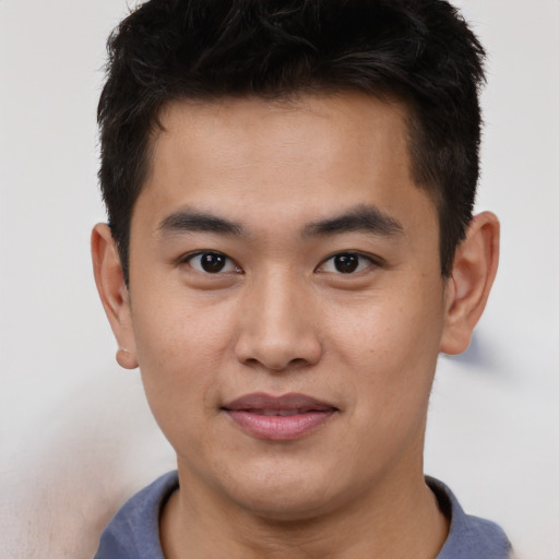 Joyful asian young-adult male with short  brown hair and brown eyes