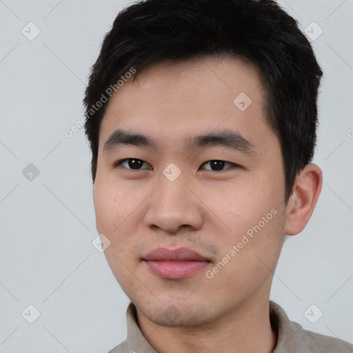 Joyful asian young-adult male with short  black hair and brown eyes