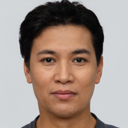 Joyful asian young-adult male with short  black hair and brown eyes