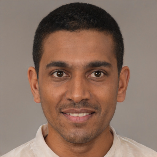 Joyful black young-adult male with short  black hair and brown eyes
