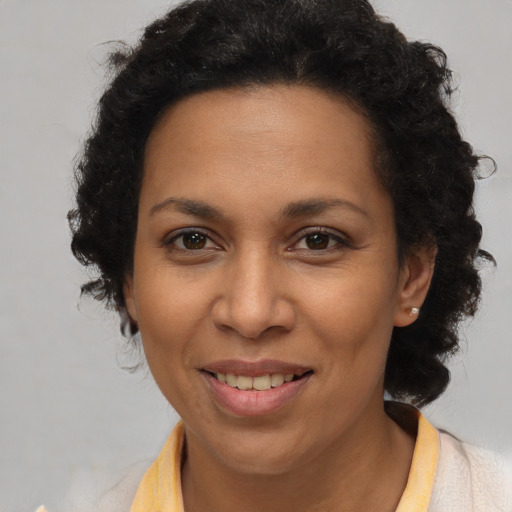Joyful latino adult female with short  brown hair and brown eyes