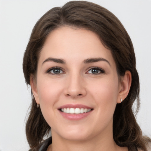 Joyful white young-adult female with long  brown hair and grey eyes