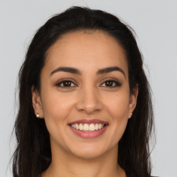 Joyful latino young-adult female with long  brown hair and brown eyes