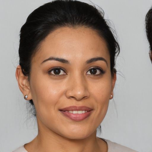 Joyful latino young-adult female with medium  brown hair and brown eyes