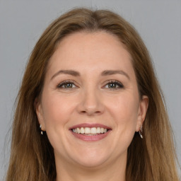 Joyful white adult female with long  brown hair and grey eyes