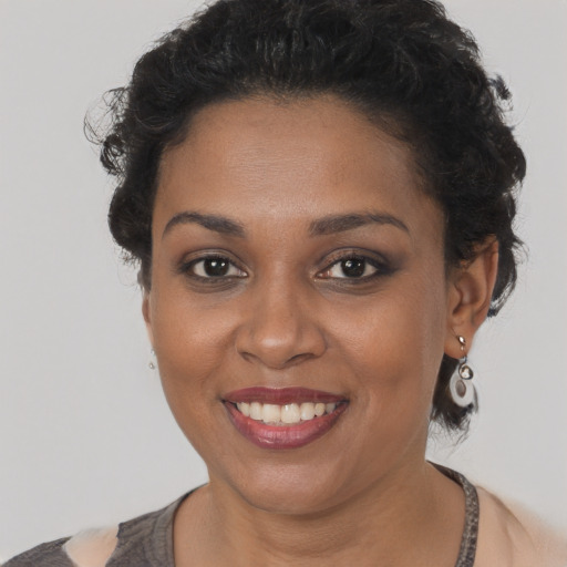Joyful black young-adult female with short  brown hair and brown eyes