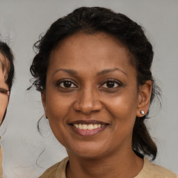 Joyful latino adult female with medium  brown hair and brown eyes