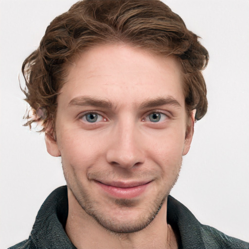 Joyful white young-adult male with short  brown hair and blue eyes