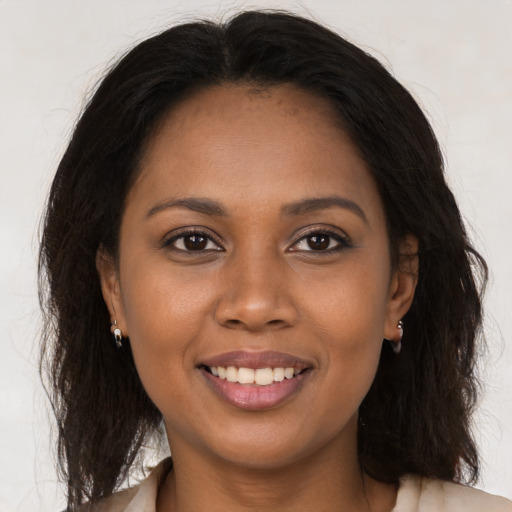 Joyful black young-adult female with long  brown hair and brown eyes