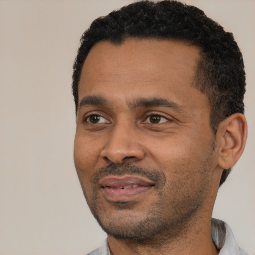 Joyful latino adult male with short  black hair and brown eyes