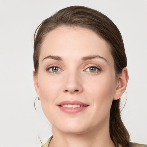 Joyful white young-adult female with medium  brown hair and grey eyes