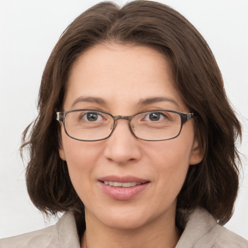 Joyful white adult female with medium  brown hair and grey eyes