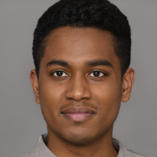 Joyful black young-adult male with short  black hair and brown eyes