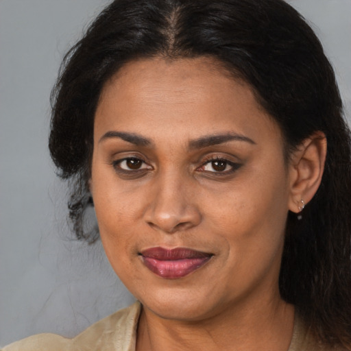 Joyful black adult female with medium  brown hair and brown eyes