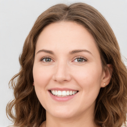 Joyful white young-adult female with long  brown hair and green eyes