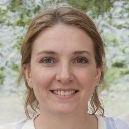 Joyful white young-adult female with medium  brown hair and grey eyes