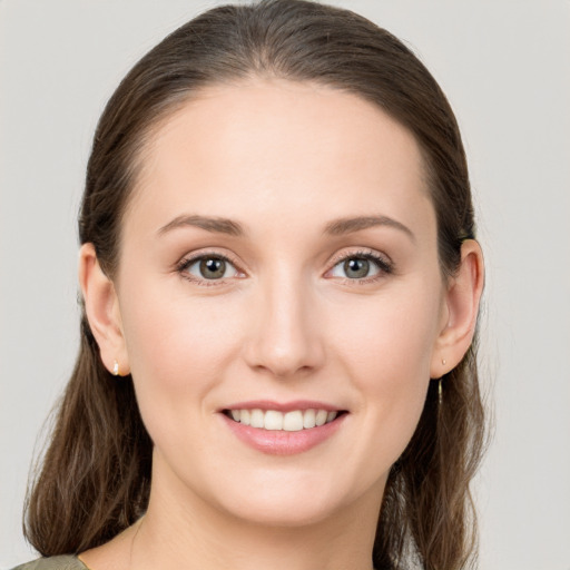 Joyful white young-adult female with long  brown hair and grey eyes