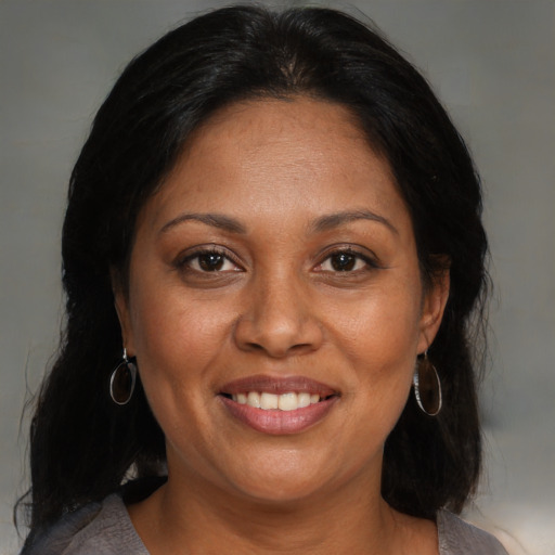 Joyful black adult female with medium  brown hair and brown eyes