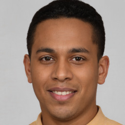 Joyful latino young-adult male with short  black hair and brown eyes