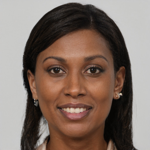 Joyful black young-adult female with long  brown hair and brown eyes