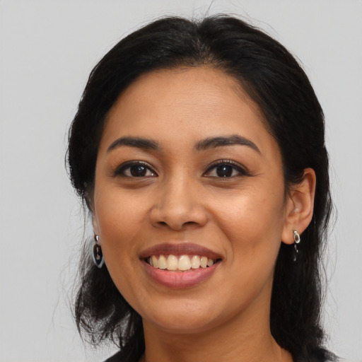 Joyful latino young-adult female with long  black hair and brown eyes