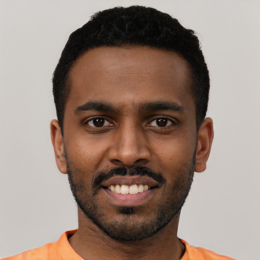 Joyful black young-adult male with short  black hair and brown eyes