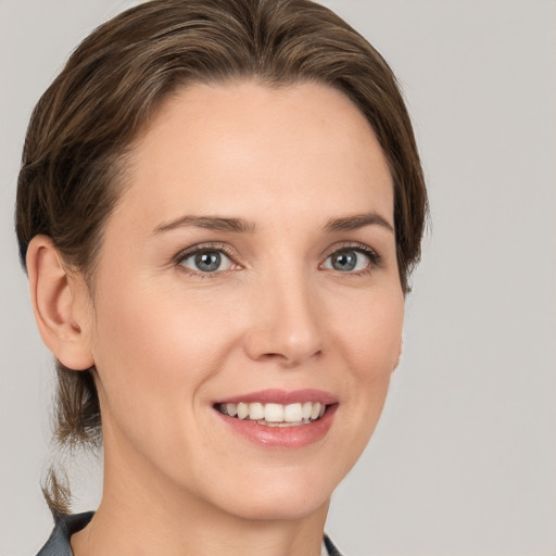 Joyful white young-adult female with medium  brown hair and grey eyes