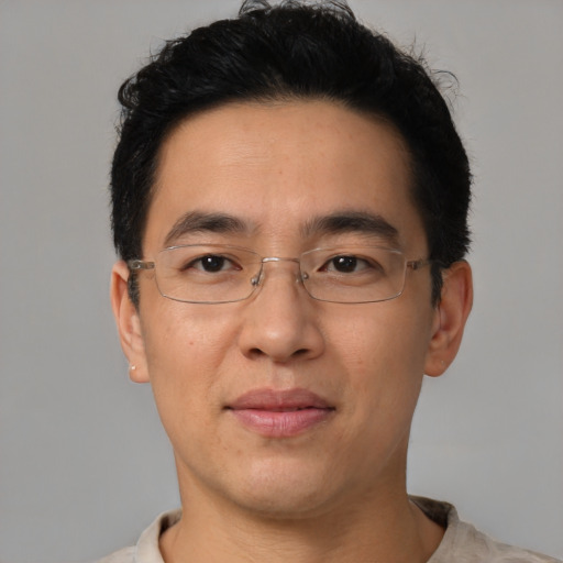 Joyful asian adult male with short  brown hair and brown eyes
