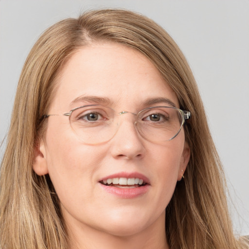 Joyful white adult female with long  brown hair and grey eyes