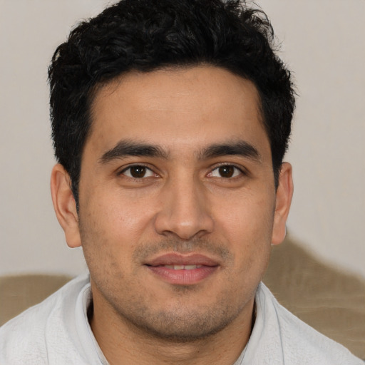 Joyful latino young-adult male with short  brown hair and brown eyes