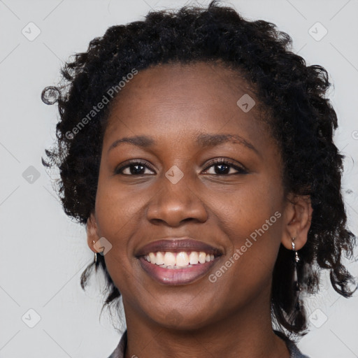 Joyful black young-adult female with long  black hair and brown eyes