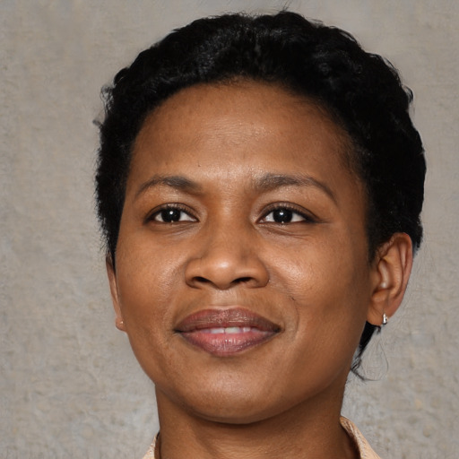 Joyful black adult female with short  black hair and brown eyes