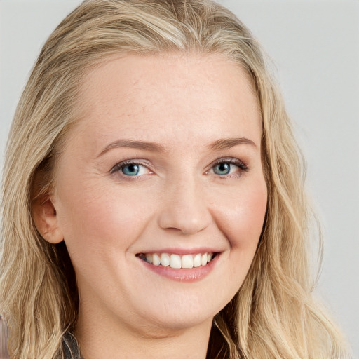 Joyful white young-adult female with long  brown hair and blue eyes