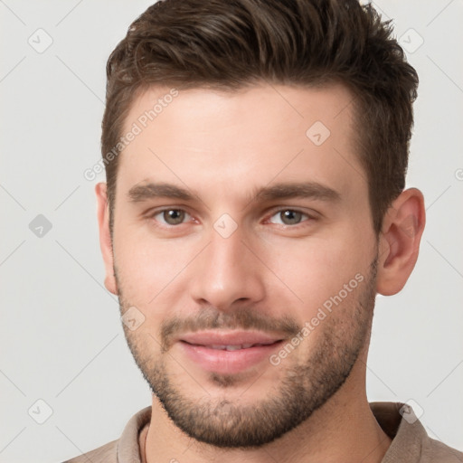 Joyful white young-adult male with short  brown hair and brown eyes