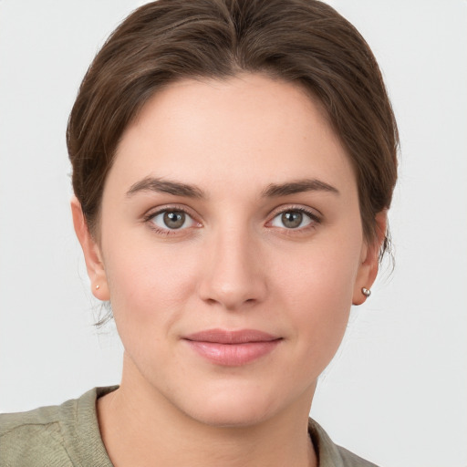 Joyful white young-adult female with short  brown hair and grey eyes