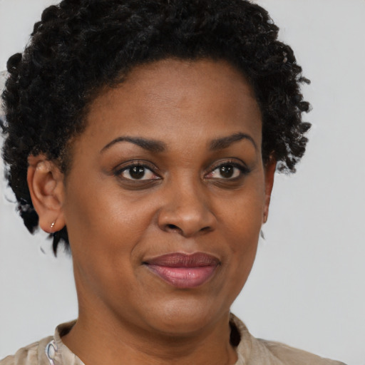 Joyful black young-adult female with short  brown hair and brown eyes