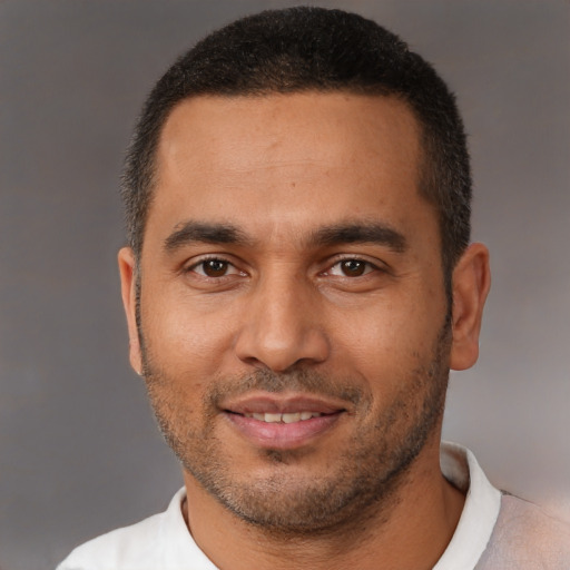 Joyful black young-adult male with short  brown hair and brown eyes