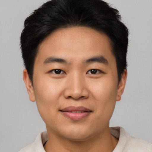 Joyful asian young-adult male with short  brown hair and brown eyes