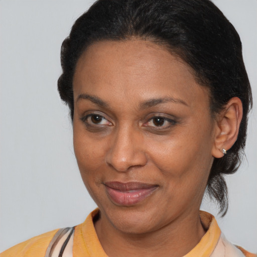 Joyful black adult female with medium  brown hair and brown eyes