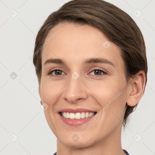 Joyful white young-adult female with short  brown hair and grey eyes