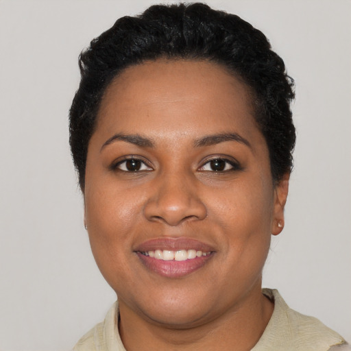 Joyful black young-adult female with short  black hair and brown eyes