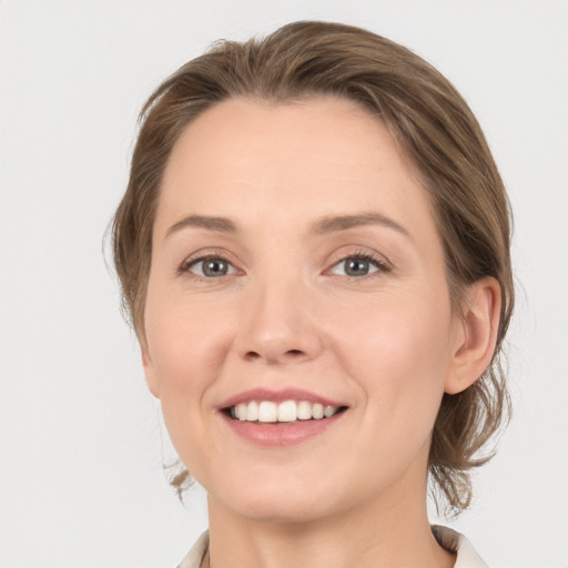 Joyful white young-adult female with medium  brown hair and grey eyes