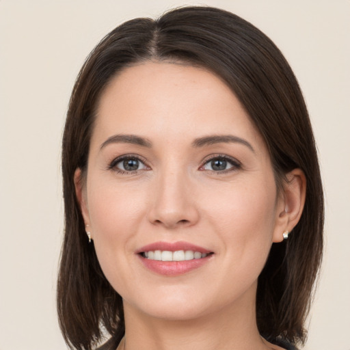 Joyful white young-adult female with medium  brown hair and grey eyes